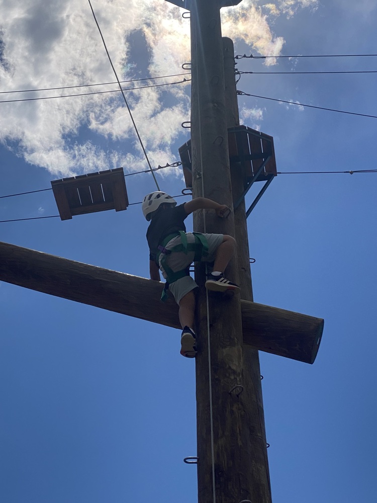 A student climbing on the high ropes challenge course. 