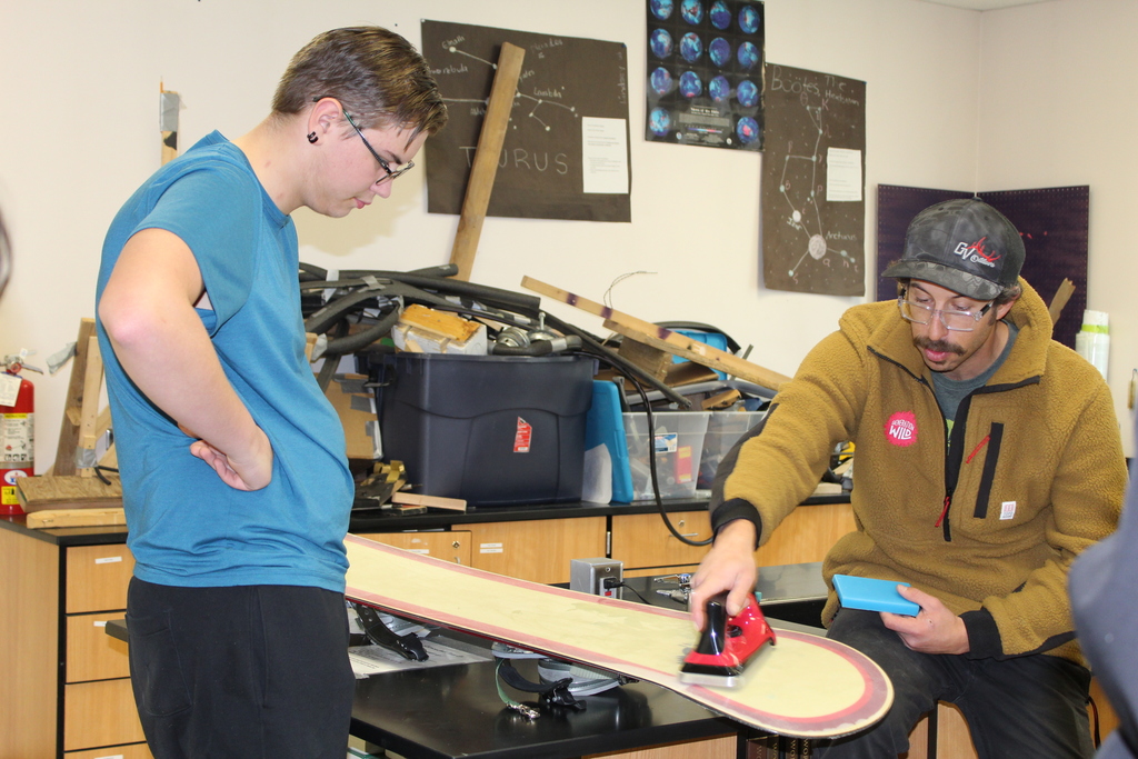 GVHS student with Ari as he demonstrates how to wax a snowboard