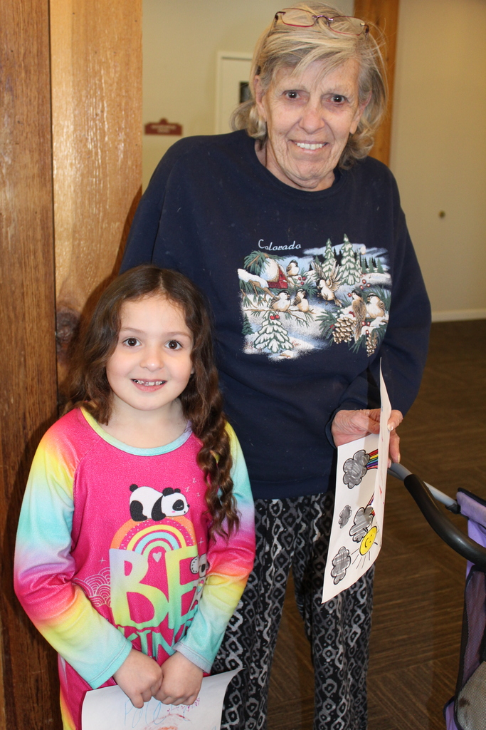 CFL student with Mesa Vista Resident and the picture the student colored to spread joy