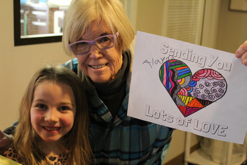 CFL student with Mesa Vista Resident and the picture the student colored to spread joy